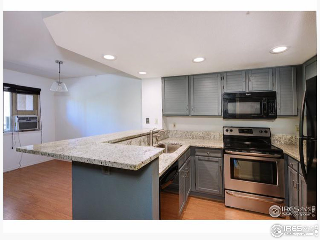 935 Broadway, Unit 106 Boulder, CO 80302 - Photo 2 of 34 a kitchen with a sink a stove a microwave and wooden cabinets