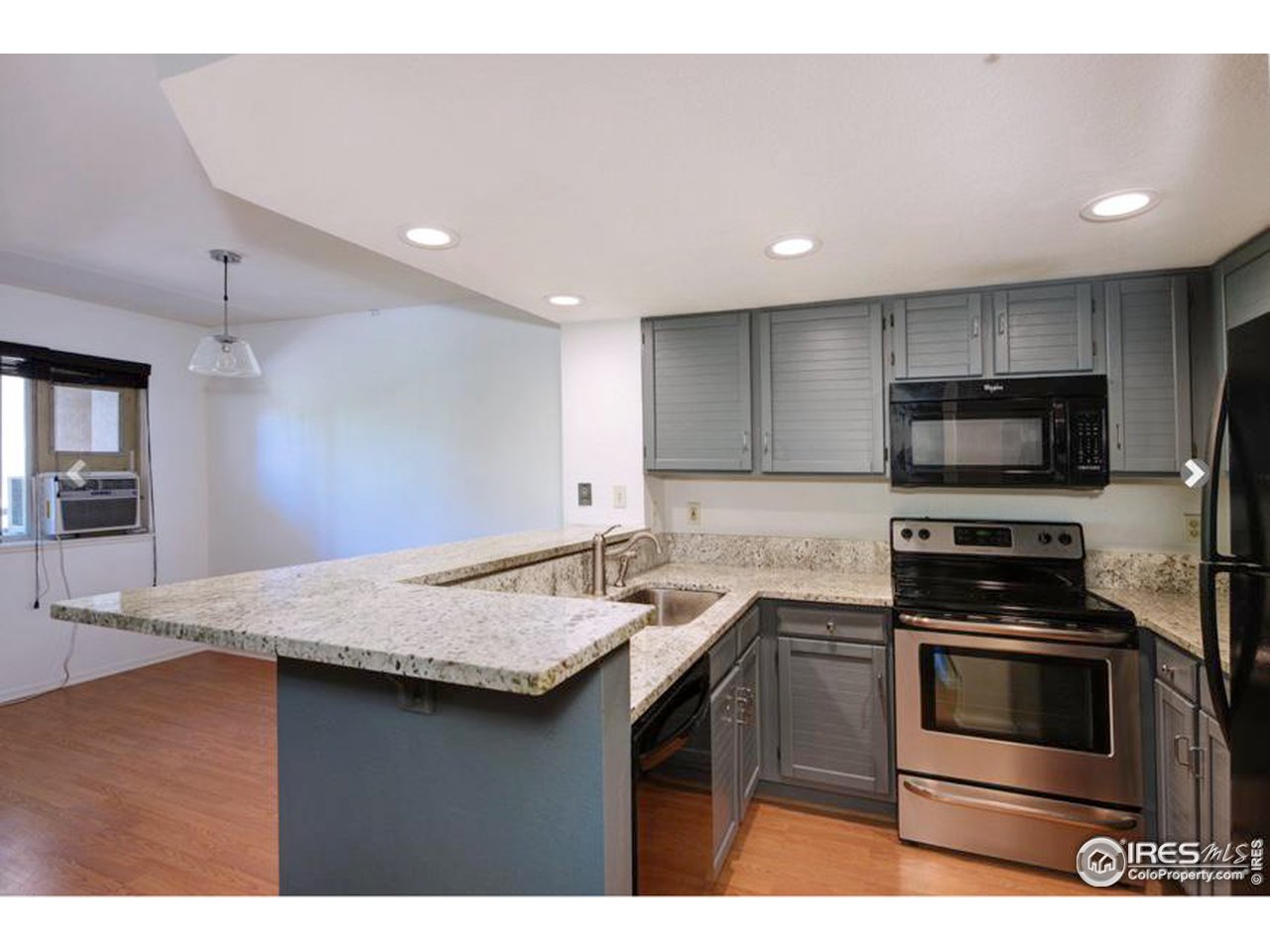 935 Broadway, Unit 106 Boulder, CO 80302 - Photo 24 of 34 a kitchen with stainless steel appliances kitchen island granite countertop a stove a sink and a microwave