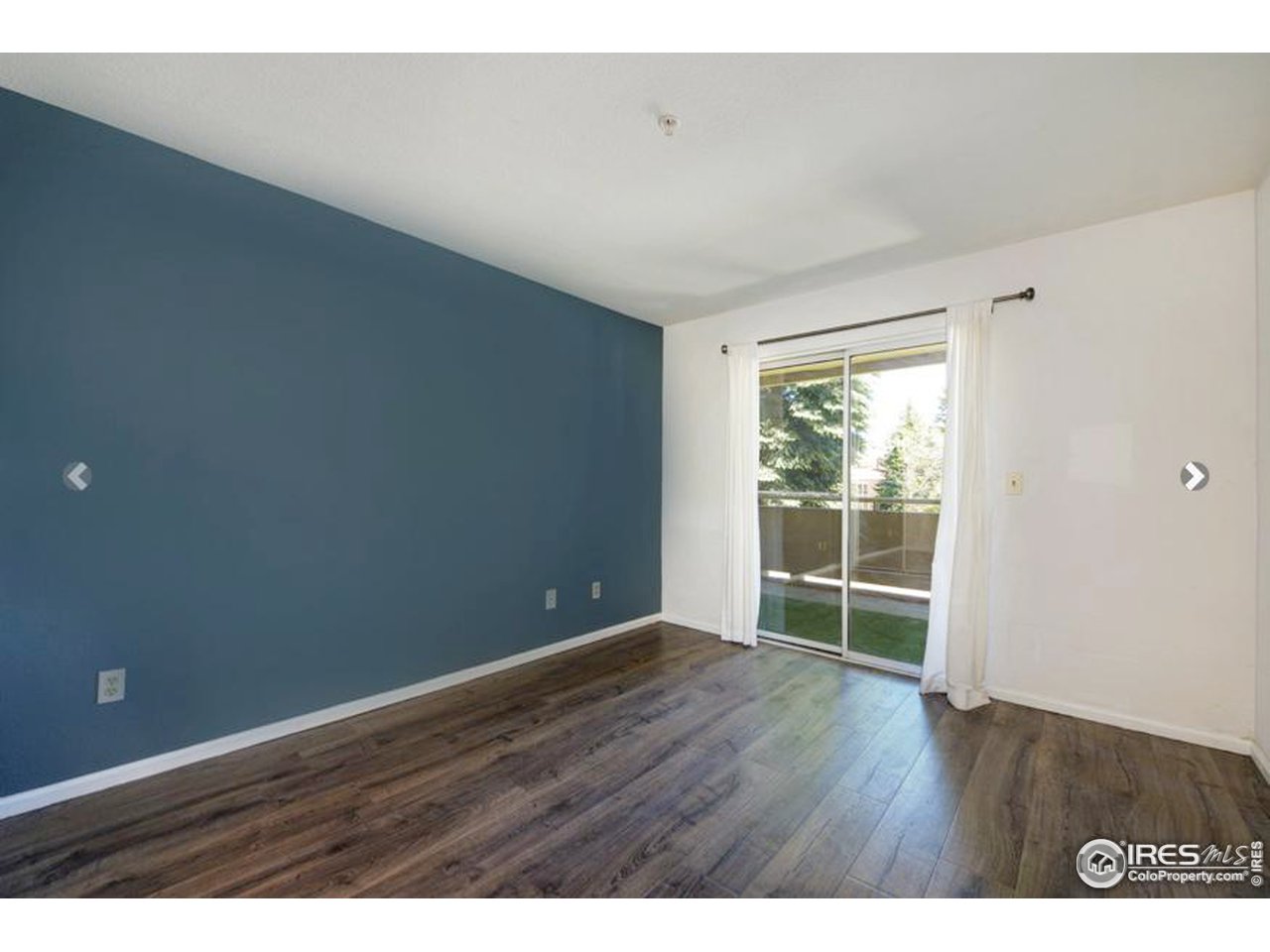 935 Broadway, Unit 106 Boulder, CO 80302 - Photo 29 of 34 a view of an empty room with wooden floor and a window
