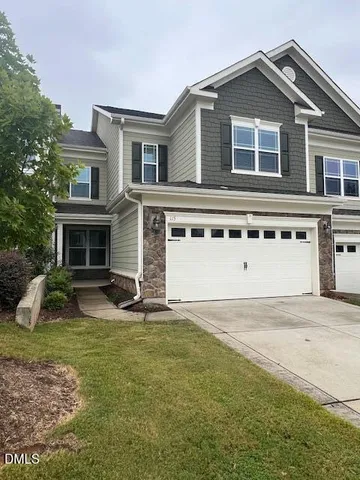 a front view of a house with a yard and garage