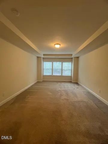 a view of a livingroom with wooden floor and a hallway