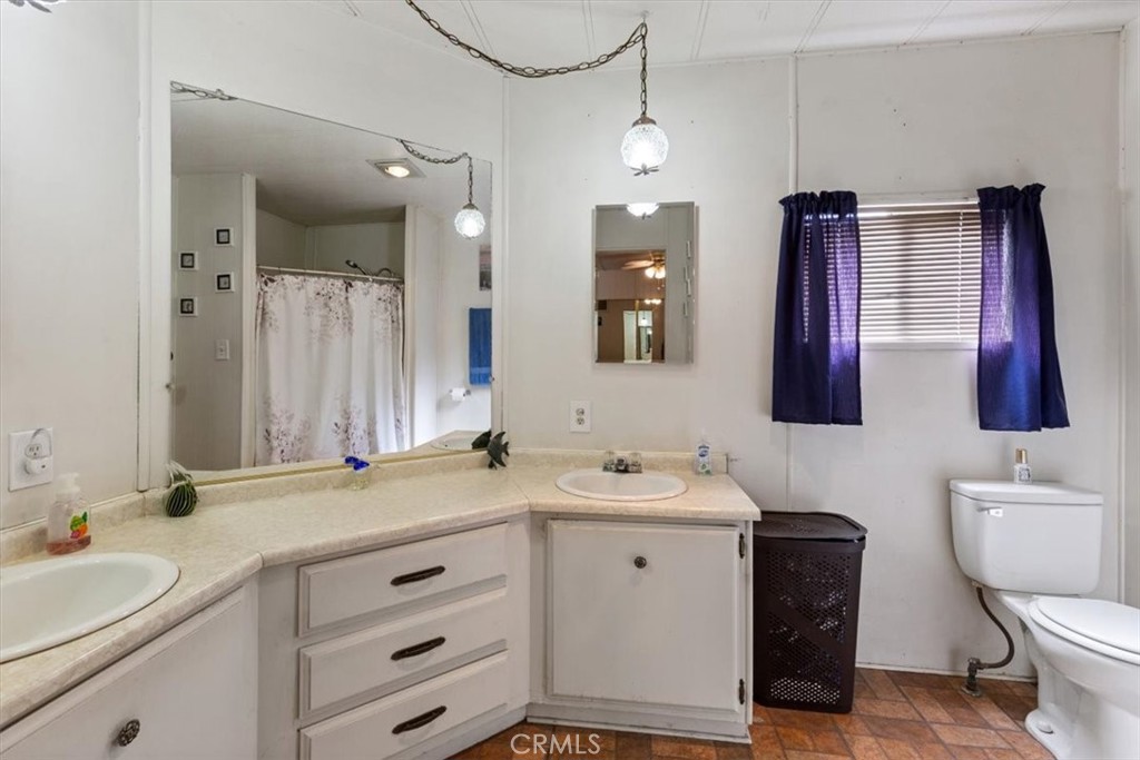 300 North Rampart Street, Unit 195 Orange, CA 92868 - Photo 18 of 25 a bathroom with a toilet a sink a mirror and vanity