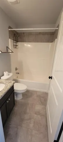 a bathroom with a granite countertop sink a toilet and bathtub