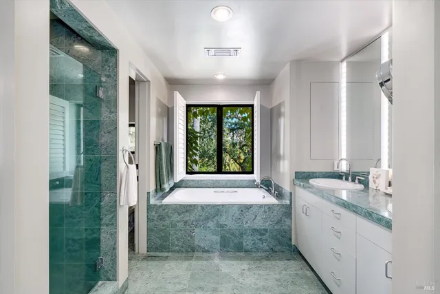 a bathroom with a granite countertop sink a toilet and shower
