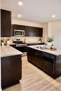 a kitchen with stainless steel appliances a sink a stove a microwave a sink a refrigerator and cabinets