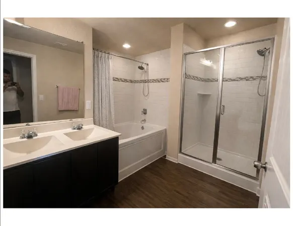 a bathroom with a tub sink shower and mirror