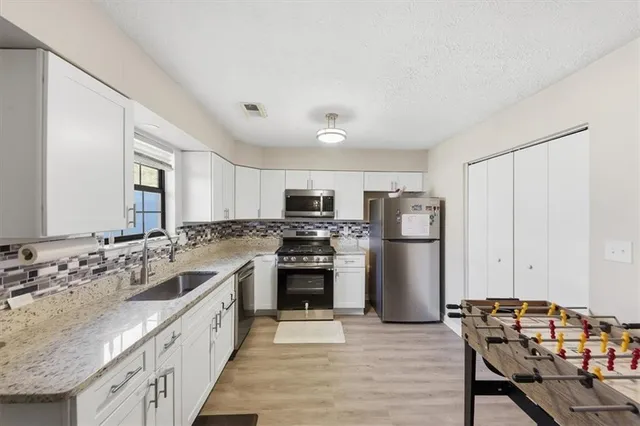 a large kitchen with a stove a refrigerator and a sink