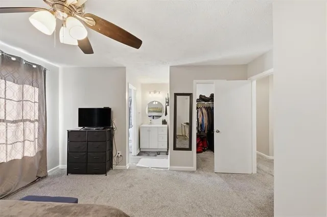 a view of a livingroom with entryway closet and a ceiling fan