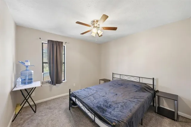 a bedroom with a bed a table and chair