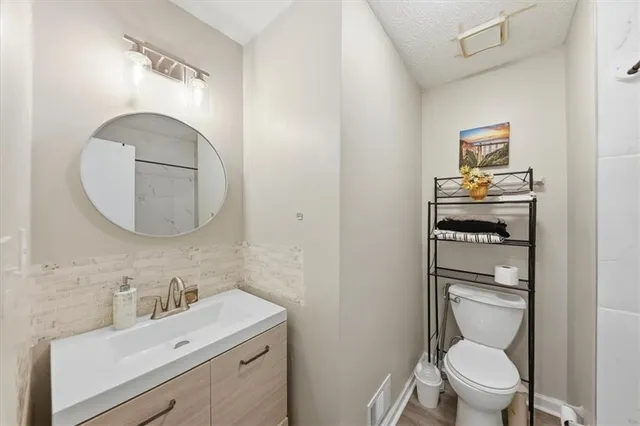 a bathroom with a toilet a sink and mirror