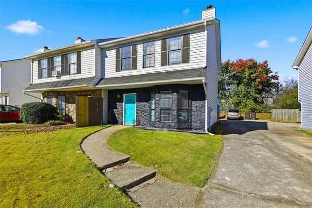 a front view of a house with yard and furniture