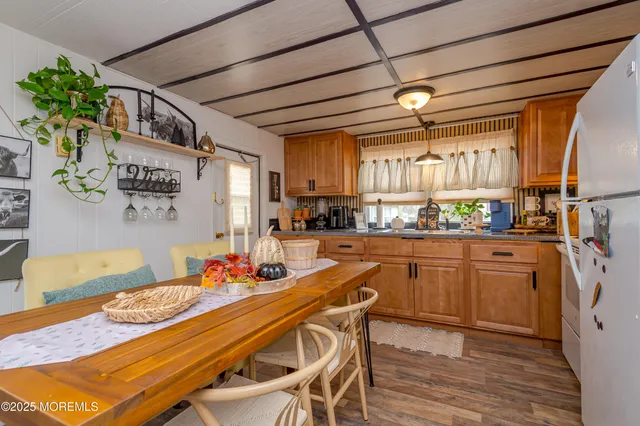 a kitchen with stainless steel appliances granite countertop a sink dishwasher and a refrigerator with wooden floor