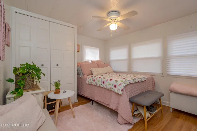a bedroom with a bed table chair and a window