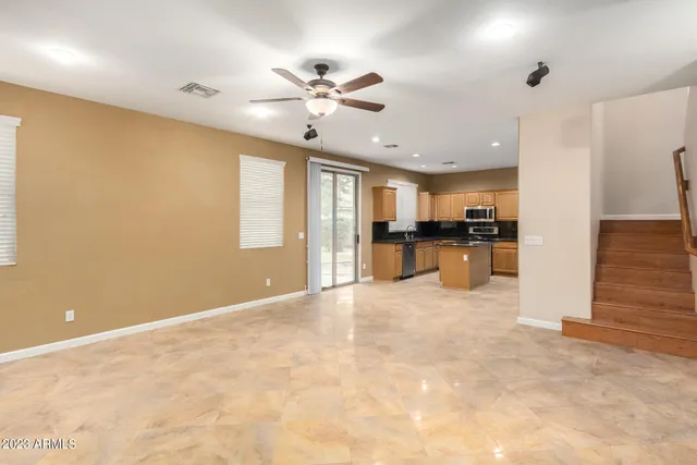 an empty room with windows and ceiling fan