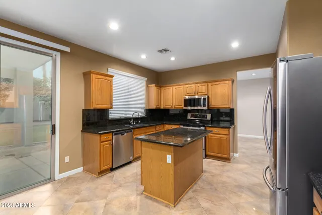 a kitchen with stainless steel appliances a refrigerator a stove a sink a microwave a counter top and cabinets