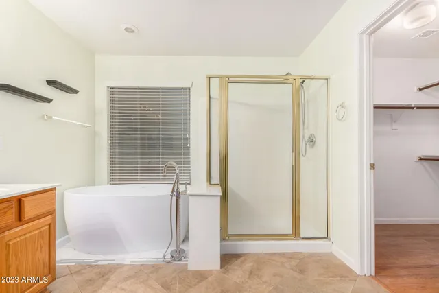 a spacious bathroom with a double vanity sink a mirror and a bathtub