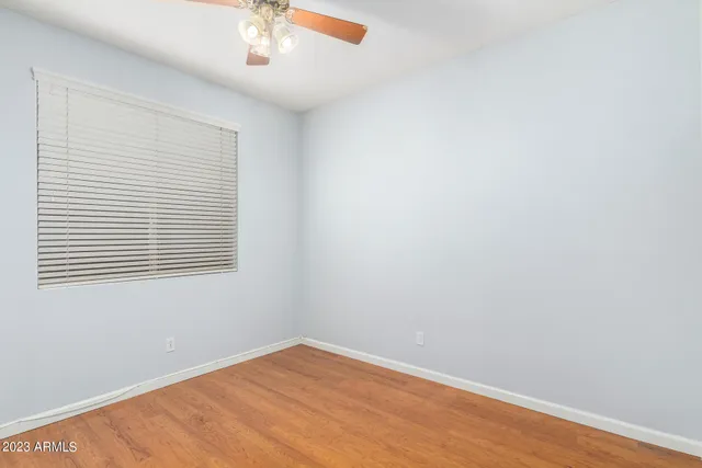 an empty room with closet and a chandelier fan