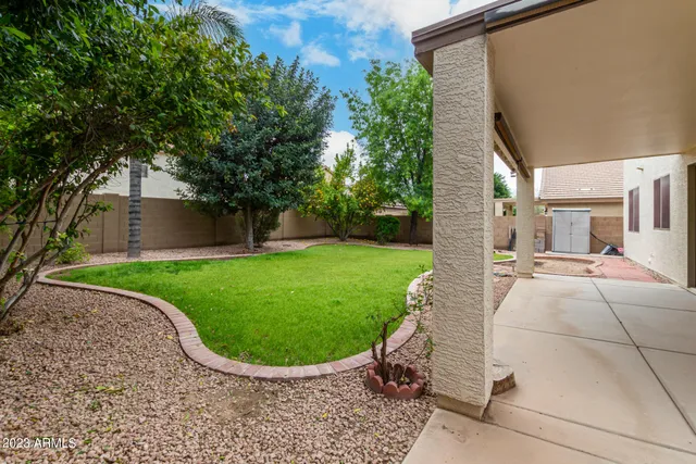 a view of a house with a yard and a large tree
