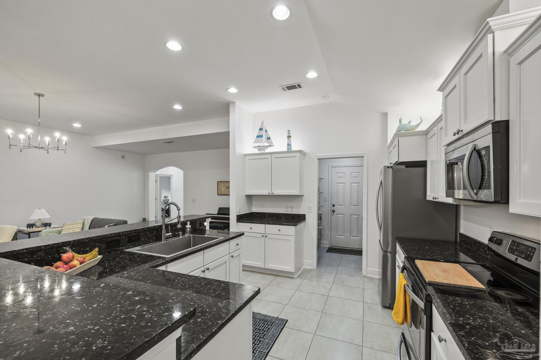 5981 Dunridge Drive Pace, FL 32571 - Photo 13 of 39 a kitchen with stainless steel appliances granite countertop a sink stove and refrigerator