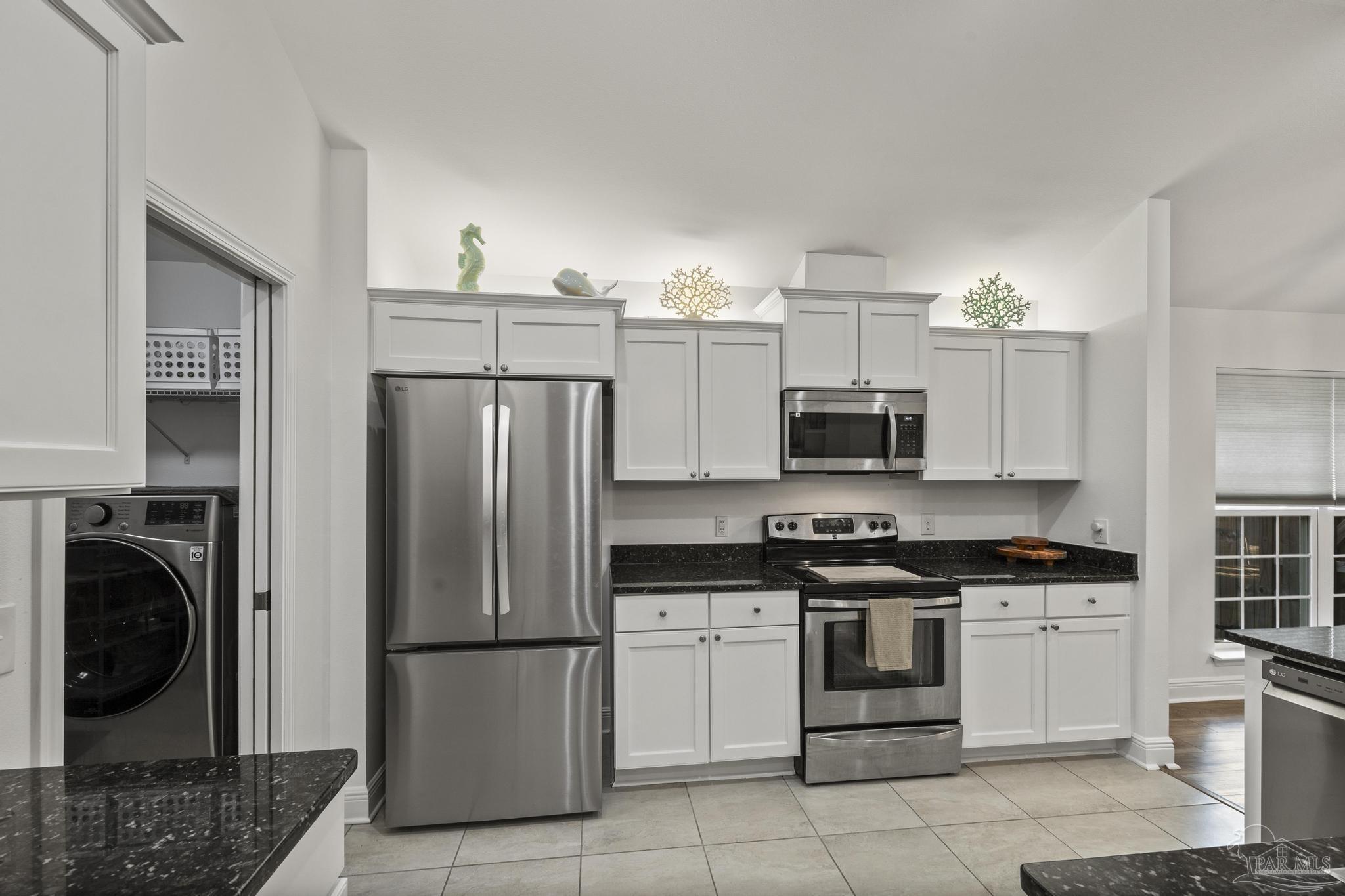 5981 Dunridge Drive Pace, FL 32571 - Photo 15 of 39 a kitchen with white cabinets and stainless steel appliances