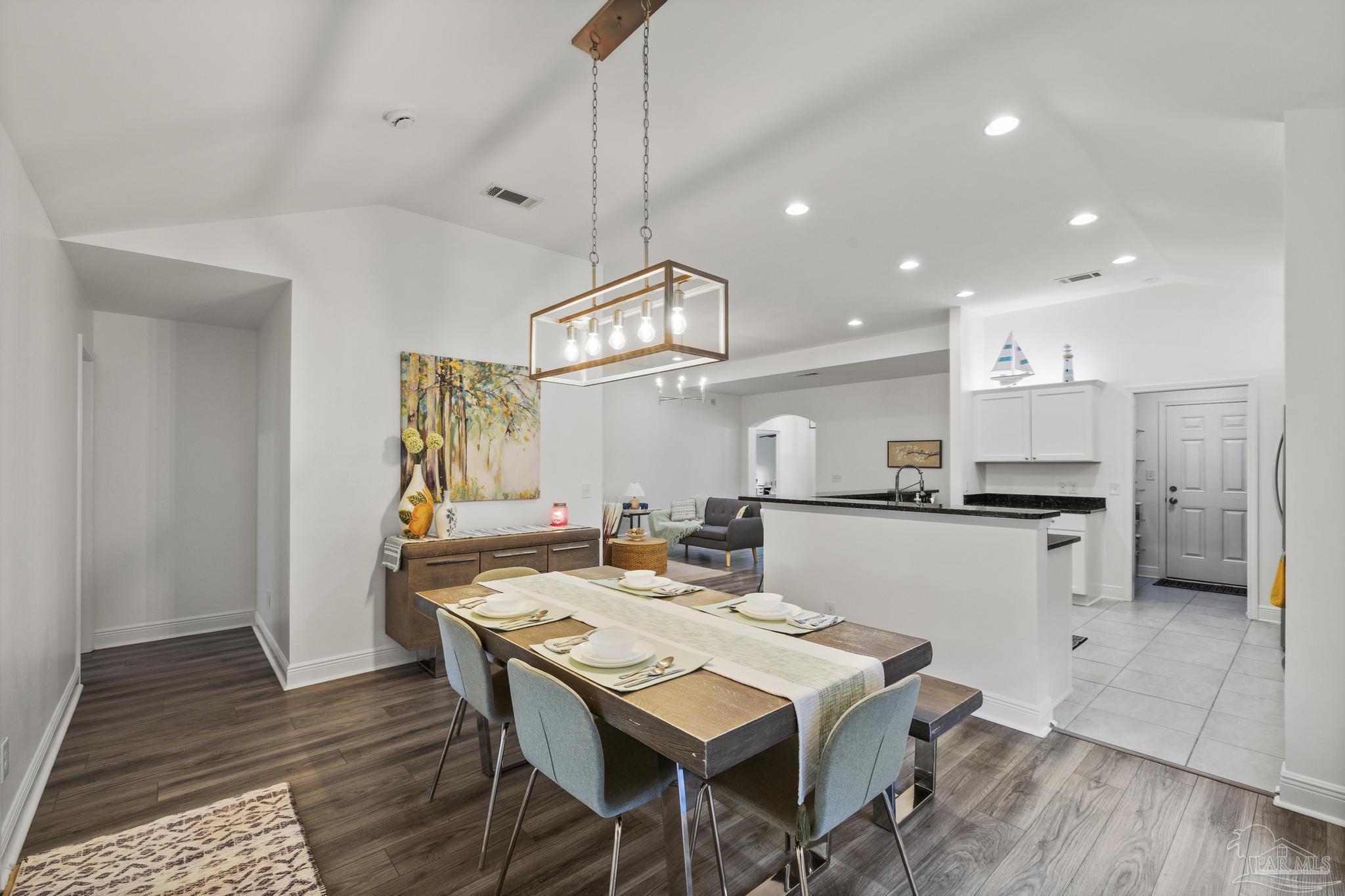5981 Dunridge Drive Pace, FL 32571 - Photo 17 of 39 a kitchen with stainless steel appliances kitchen island granite countertop a table chairs and a refrigerator