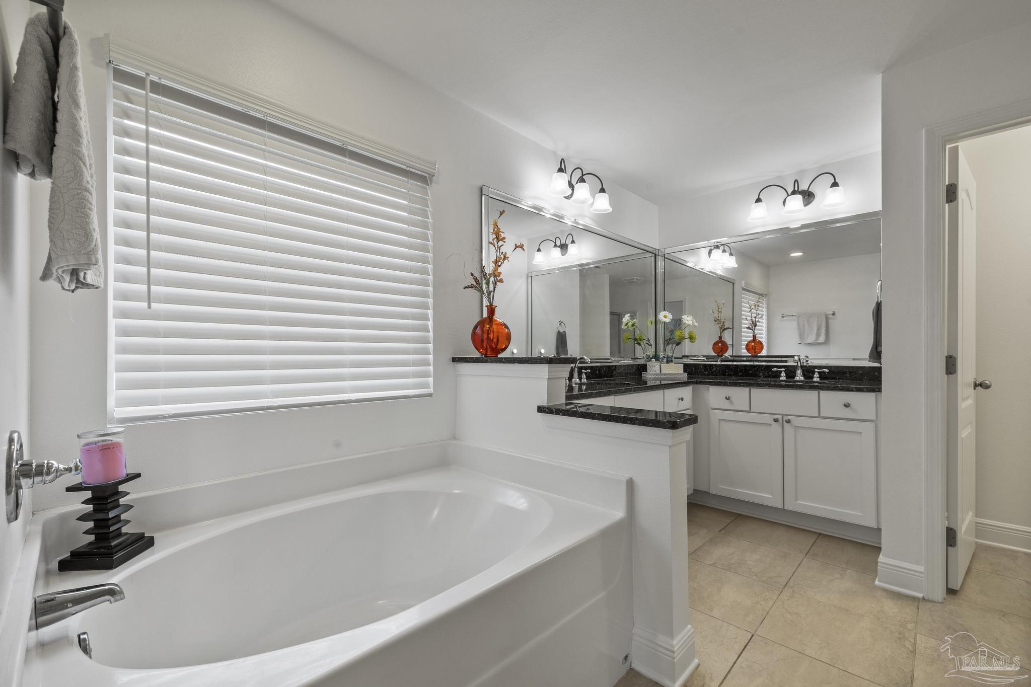 5981 Dunridge Drive Pace, FL 32571 - Photo 22 of 39 a bathroom with a tub a sink a potted plant and a window