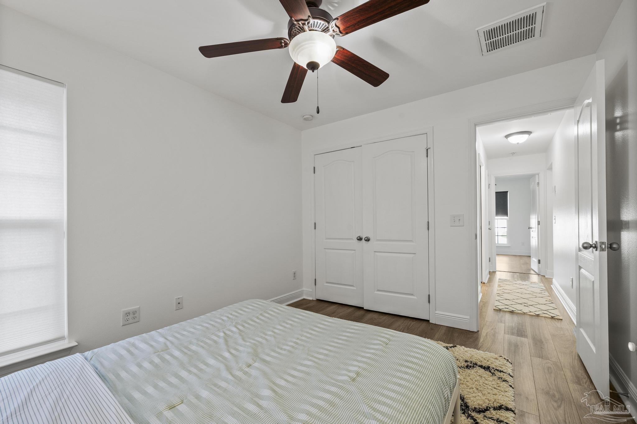 5981 Dunridge Drive Pace, FL 32571 - Photo 28 of 39 a bedroom with a bed and a chandelier fan