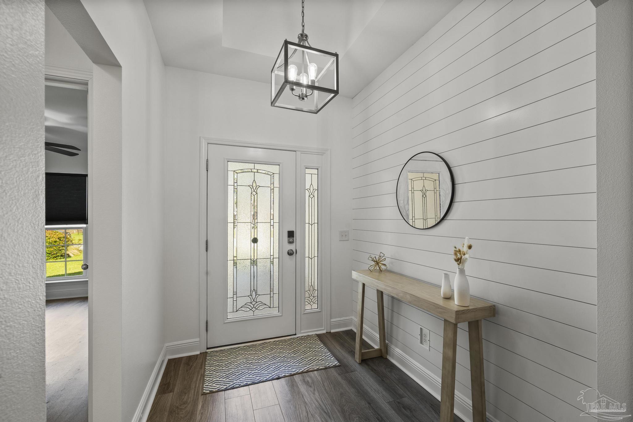 5981 Dunridge Drive Pace, FL 32571 - Photo 6 of 39 a view of a hallway with entryway wooden floor and front door