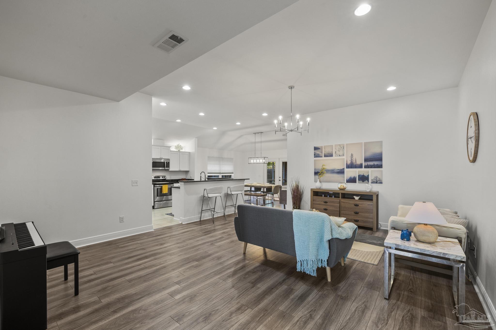 5981 Dunridge Drive Pace, FL 32571 - Photo 8 of 39 a living room with kitchen island furniture and a chandelier