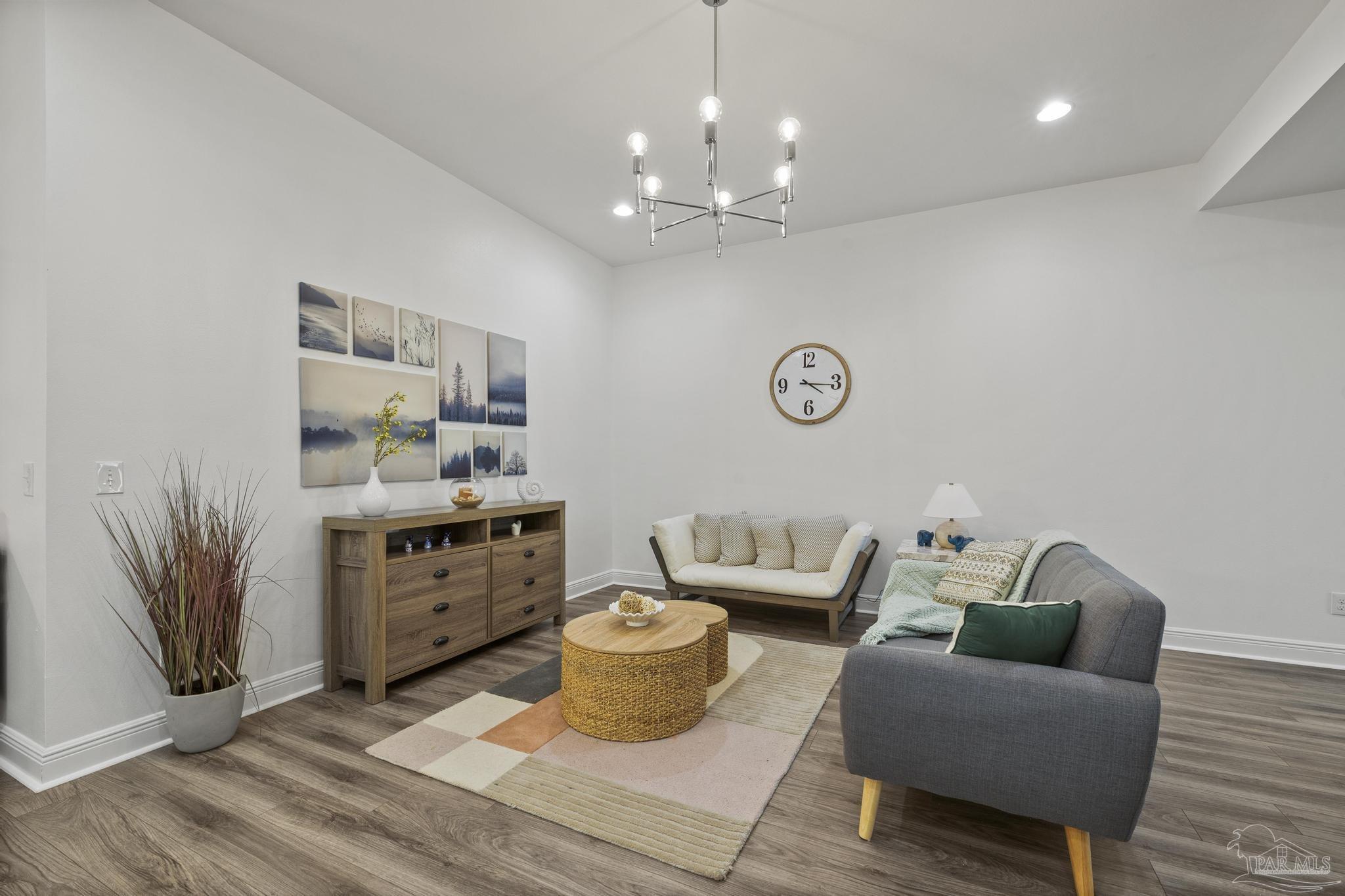 5981 Dunridge Drive Pace, FL 32571 - Photo 9 of 39 a living room with furniture a rug and a chandelier