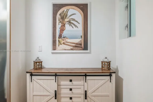 a view of room that has a mirror and cabinets in it