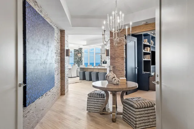 a view of a dining room with furniture a chandelier and wooden floor