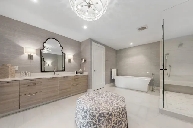 a spacious bathroom with a tub sink and mirror