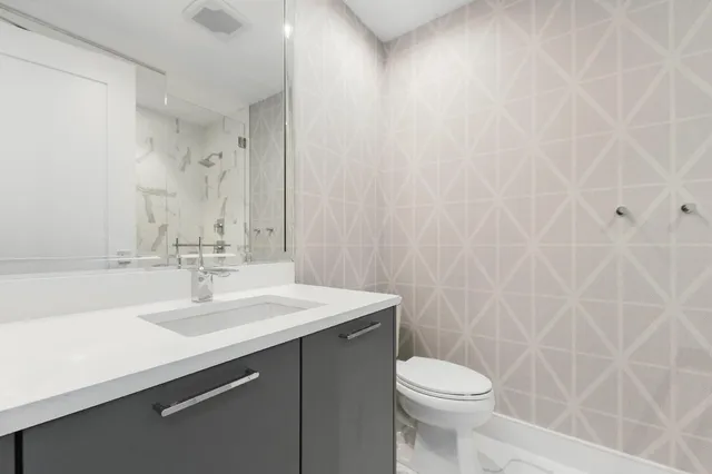 a bathroom with a sink a toilet and a mirror