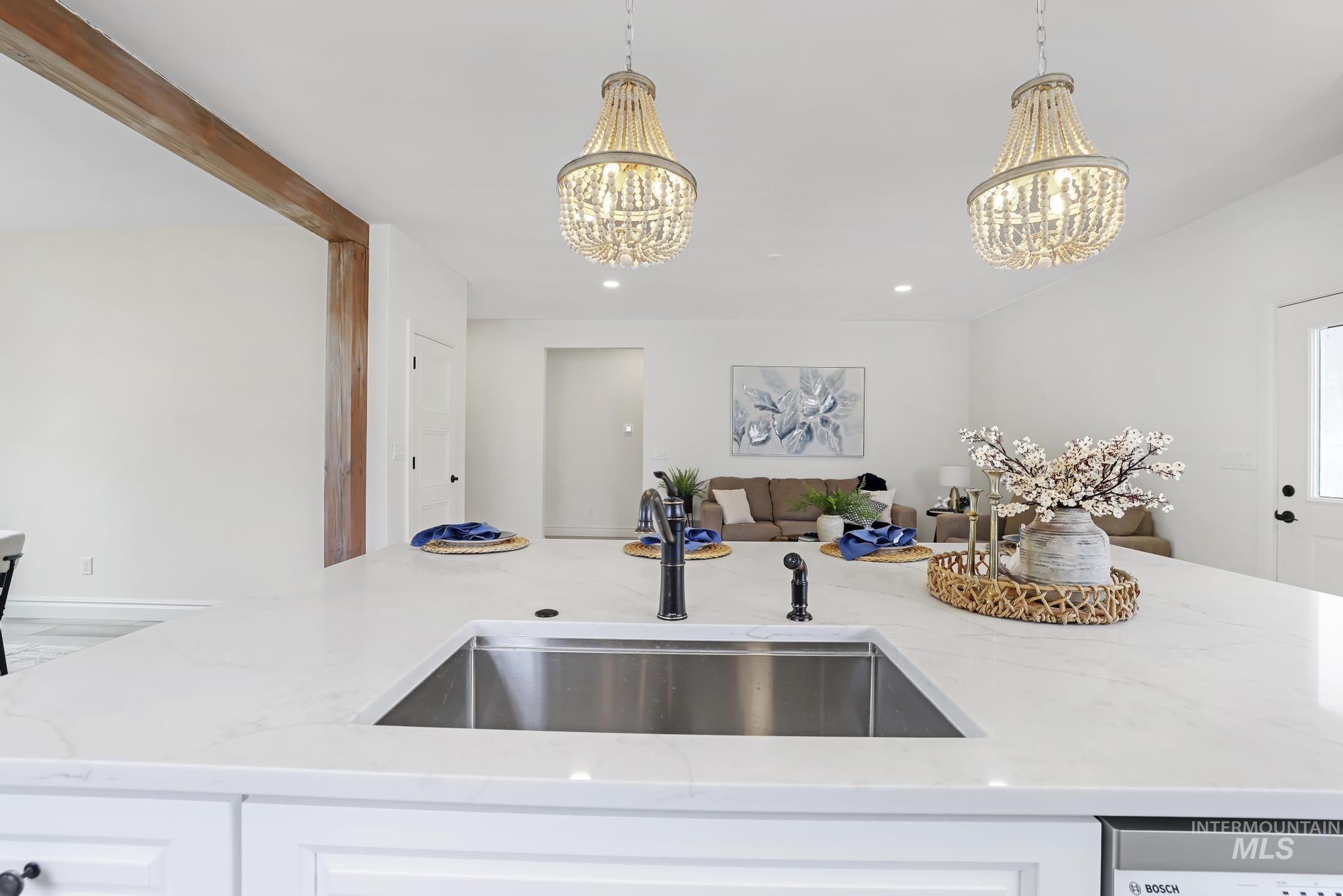 866 Quartz Road Kimberly, ID 83341 - Photo 15 of 48 Kitchen island featuring a stainless steel sink, black faucet, and white quartz countertop