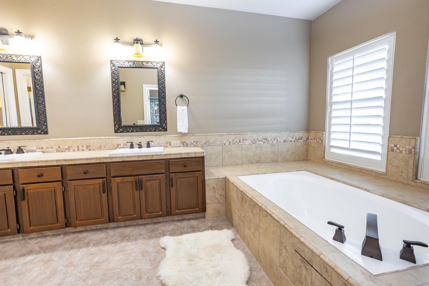 808 Country Club Drive Modesto, CA 95356 - Photo 46 of 60 a spacious bathroom with a tub sink and mirror