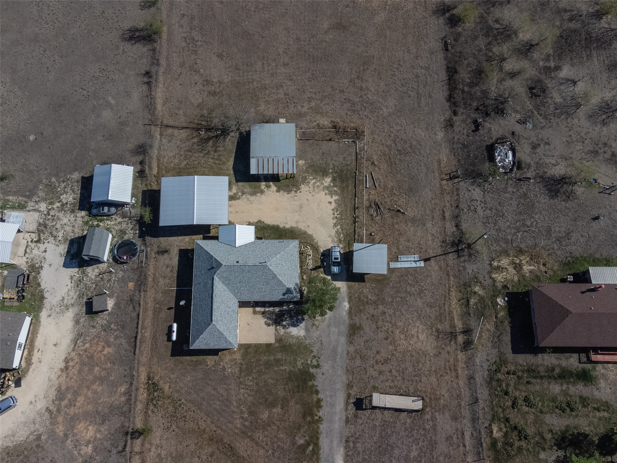 2412 Williamson Road Lockhart, TX 78644 - Photo 16 of 36 Expansive property featuring multiple outbuildings, including a large shed and a detached carport