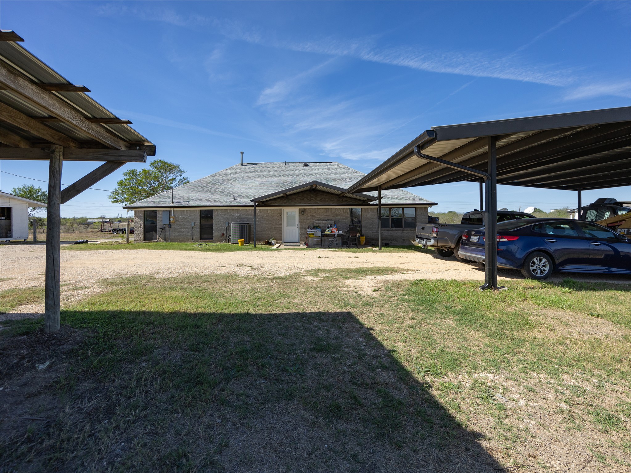 2412 Williamson Road Lockhart, TX 78644 - Photo 21 of 36 Brick exterior residence with a shingled roof and a white rear entry door