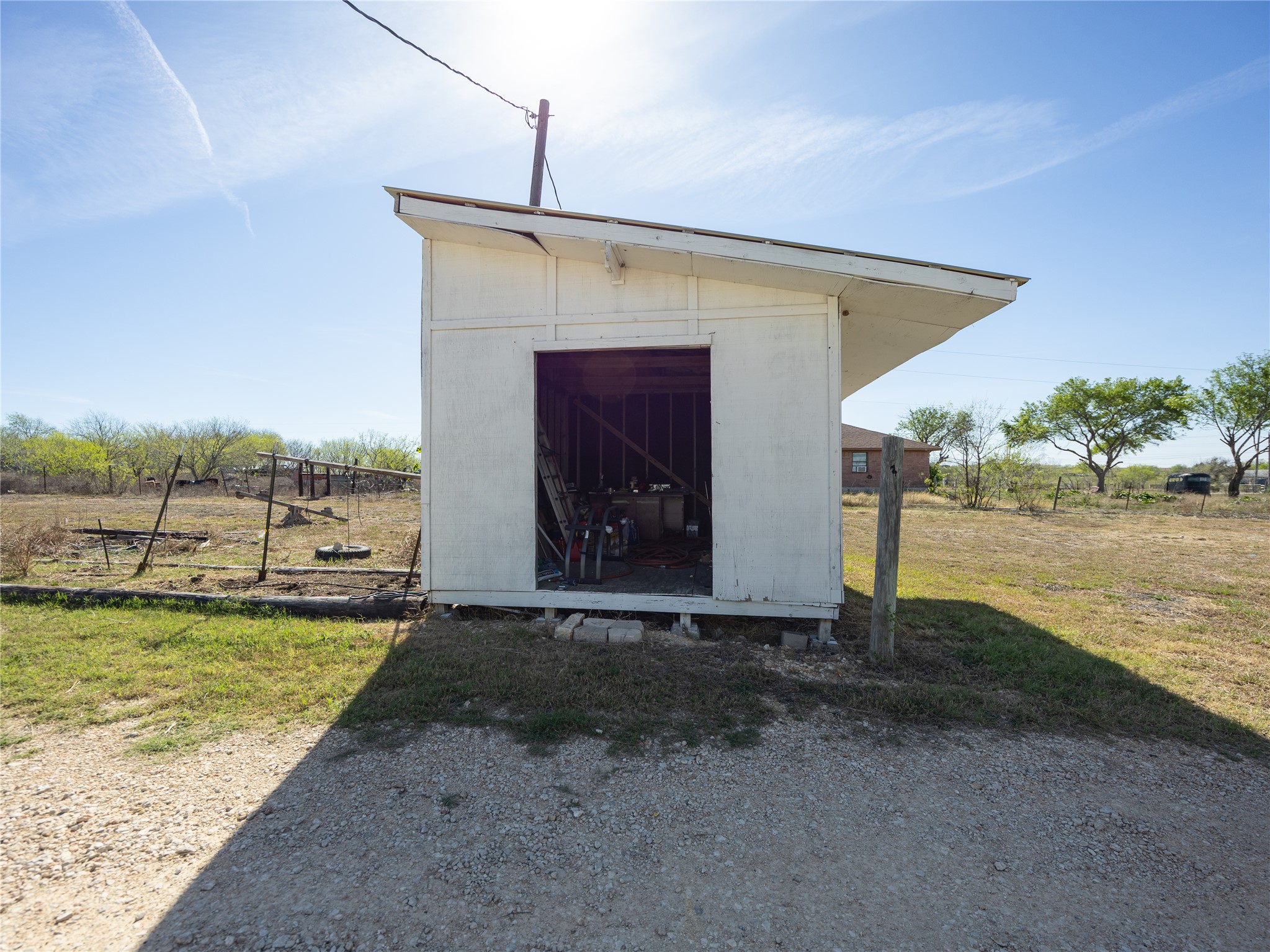 2412 Williamson Road Lockhart, TX 78644 - Photo 23 of 36 Freestanding utility shed with a white exterior finish and an open doorway
