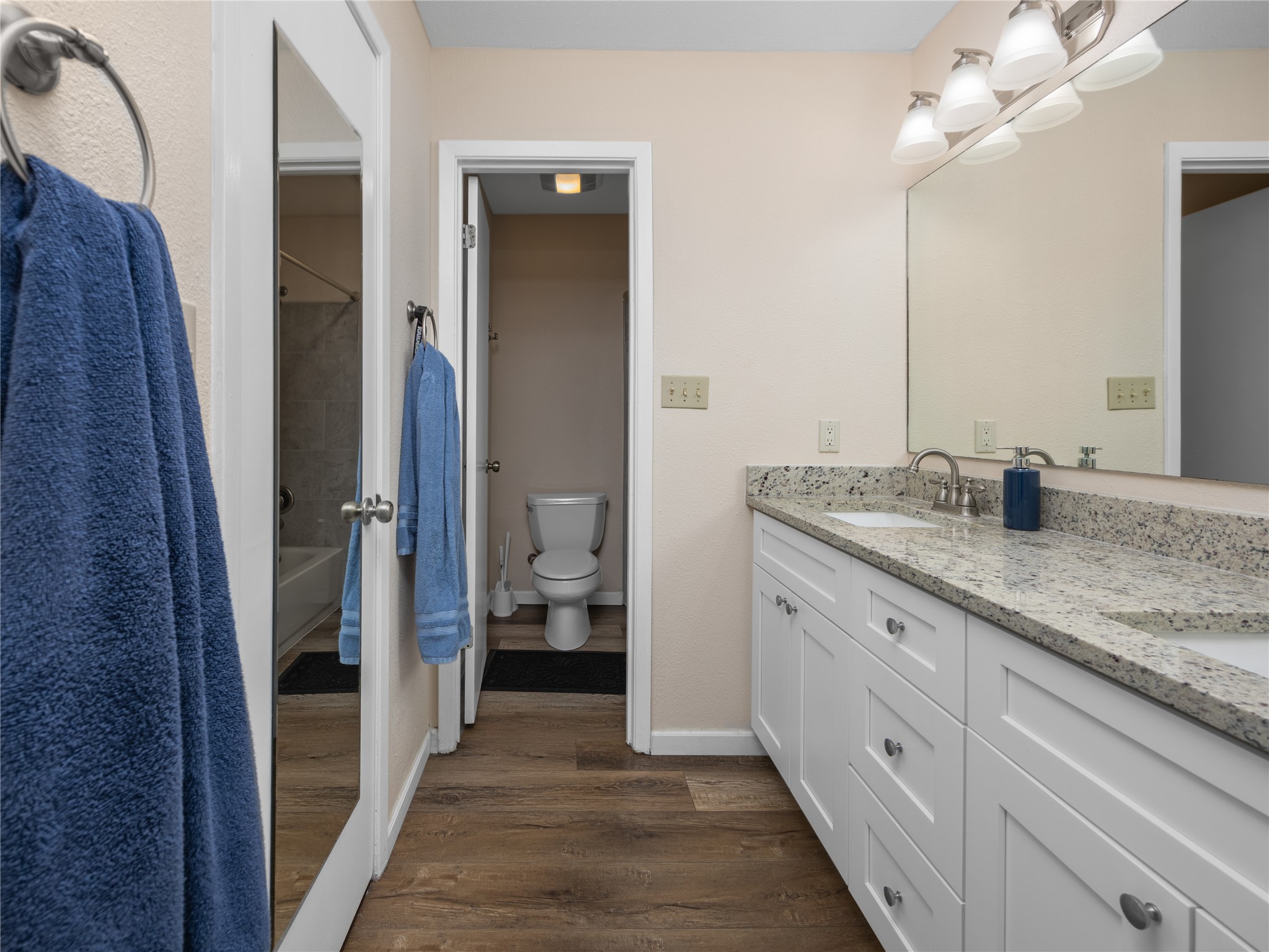 2412 Williamson Road Lockhart, TX 78644 - Photo 28 of 36 Bathroom featuring a dual vanity with white shaker-style cabinetry and a speckled countertop