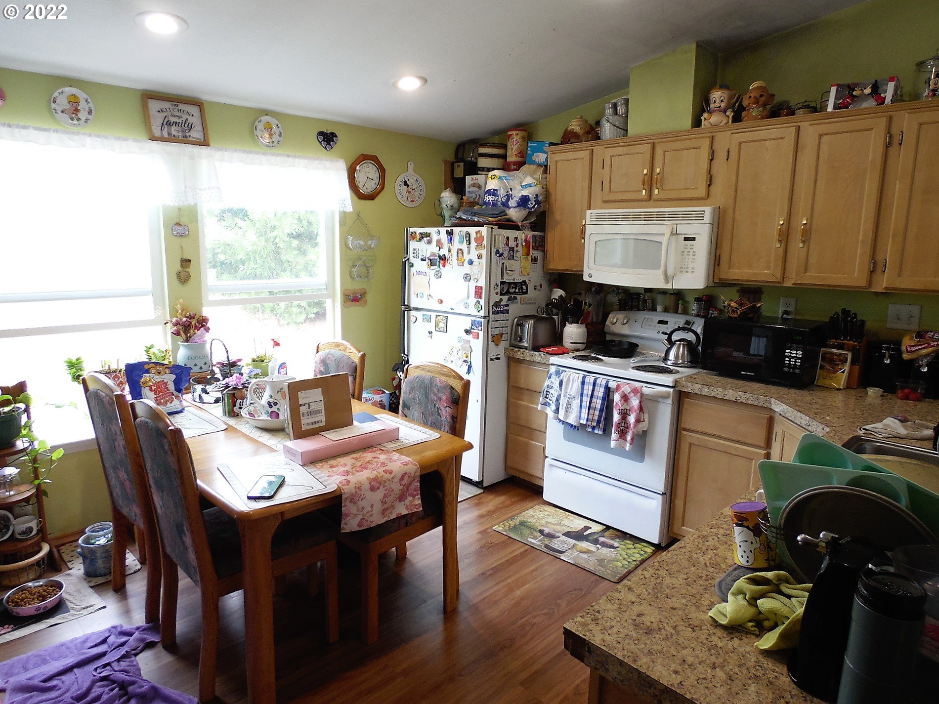 198 Council Creek Road Riddle, OR 97469 - Photo 8 of 24 a kitchen with a refrigerator a stove a sink dishwasher with a dining table and chairs with wooden floor