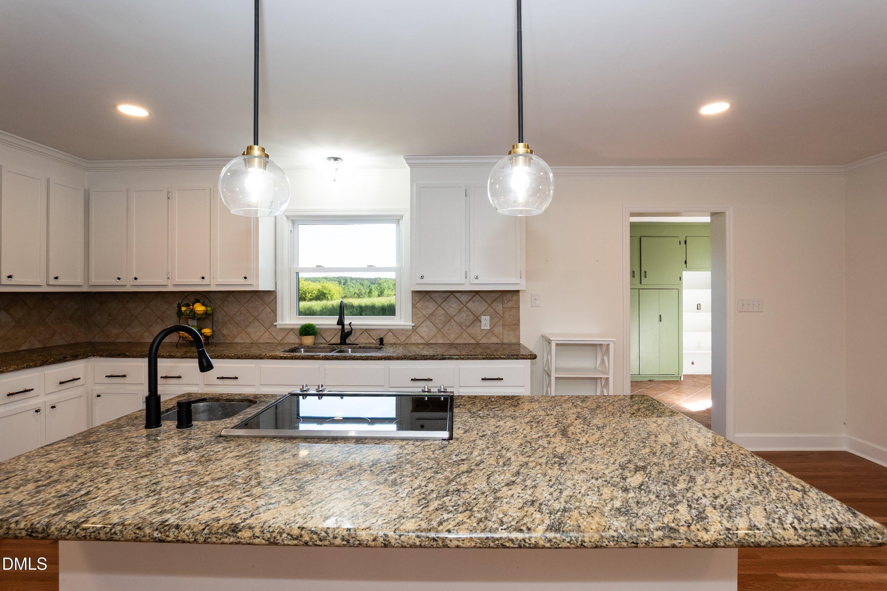 641 Rocky Ford Road Louisburg, NC 27549 - Photo 6 of 38 a kitchen with kitchen island granite countertop a stove a sink a center island and cabinets