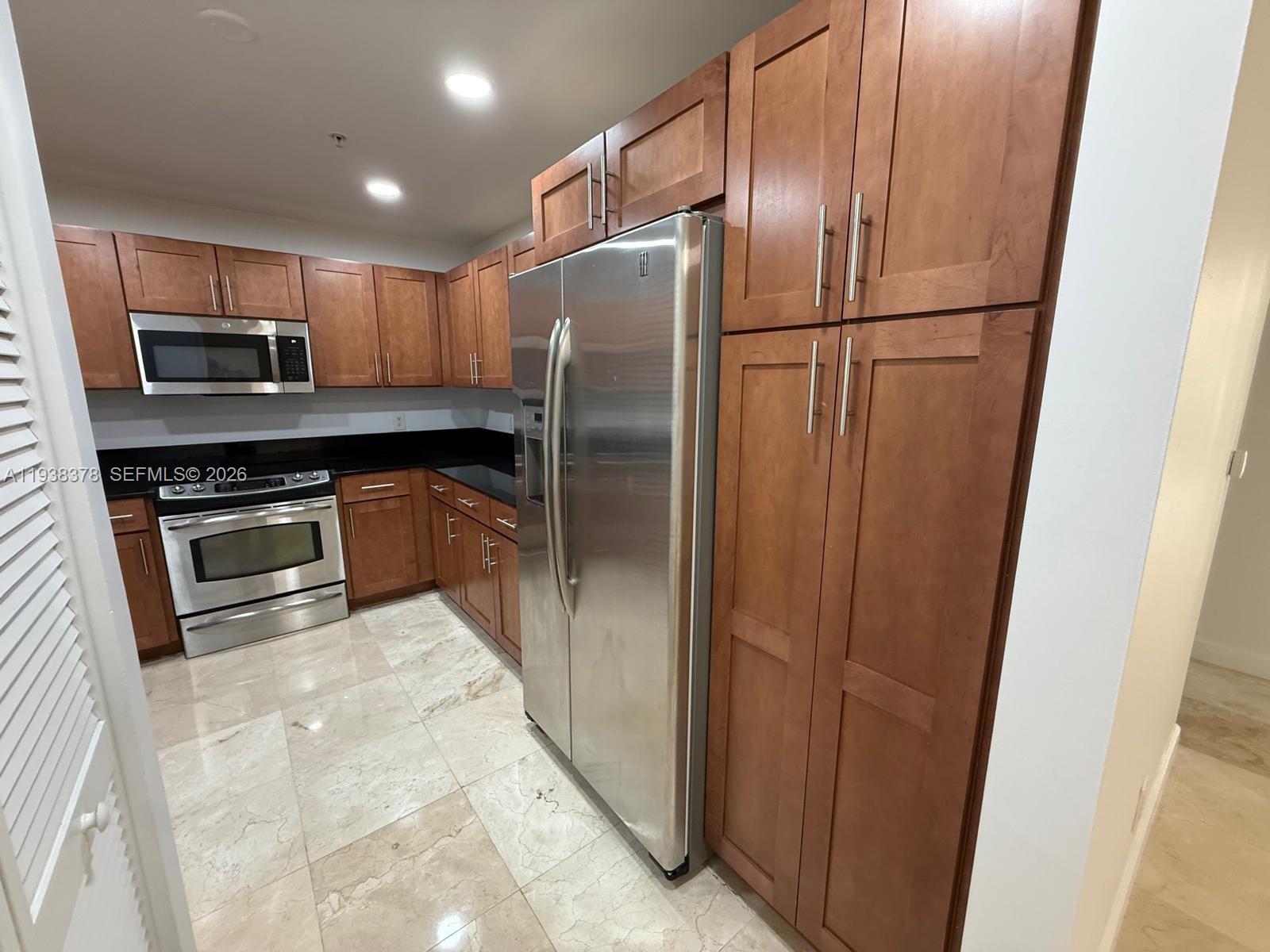 8390 Southwest 72nd Avenue, Unit 520 Miami, FL 33143 - Photo 28 of 61 a kitchen with stainless steel appliances granite countertop a refrigerator a stove a sink and a microwave
