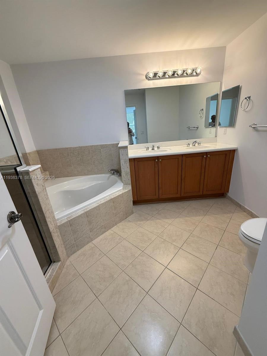 8390 Southwest 72nd Avenue, Unit 520 Miami, FL 33143 - Photo 47 of 61 a bathroom with a tub a sink and mirror