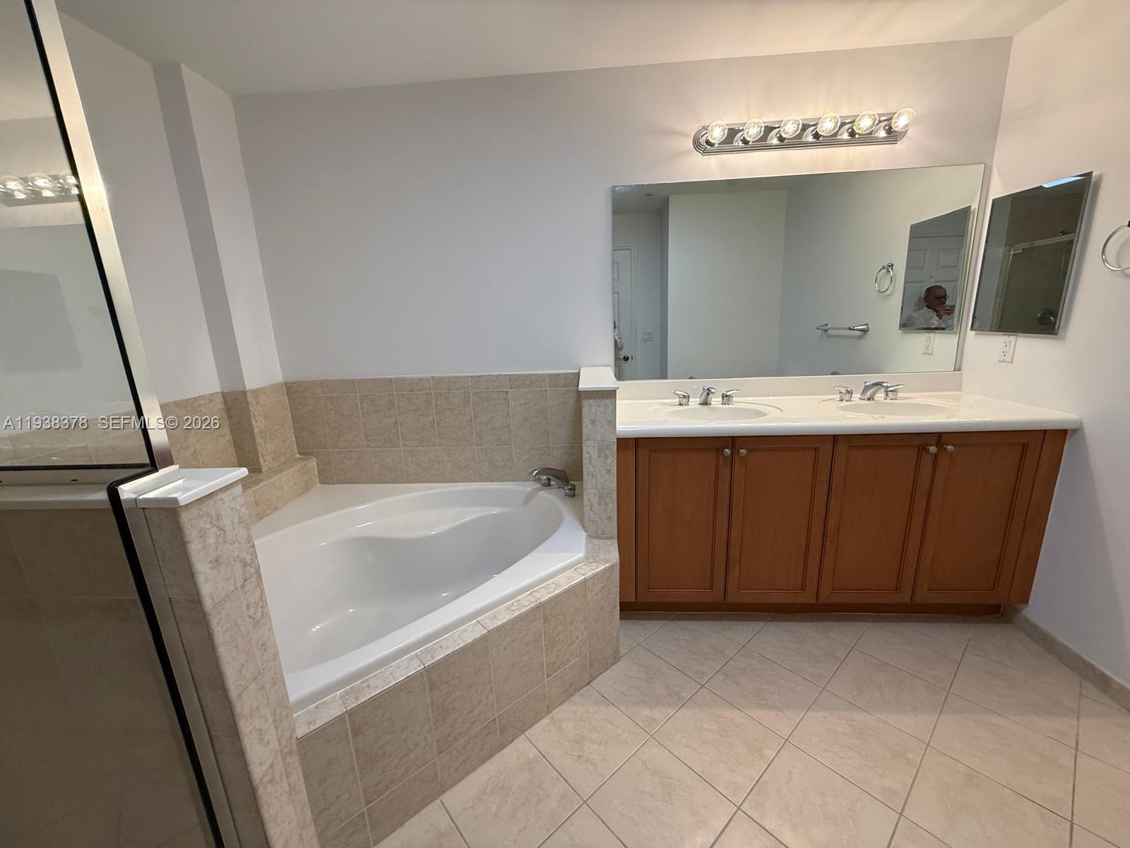 8390 Southwest 72nd Avenue, Unit 520 Miami, FL 33143 - Photo 48 of 61 a bathroom with a tub sink and mirror