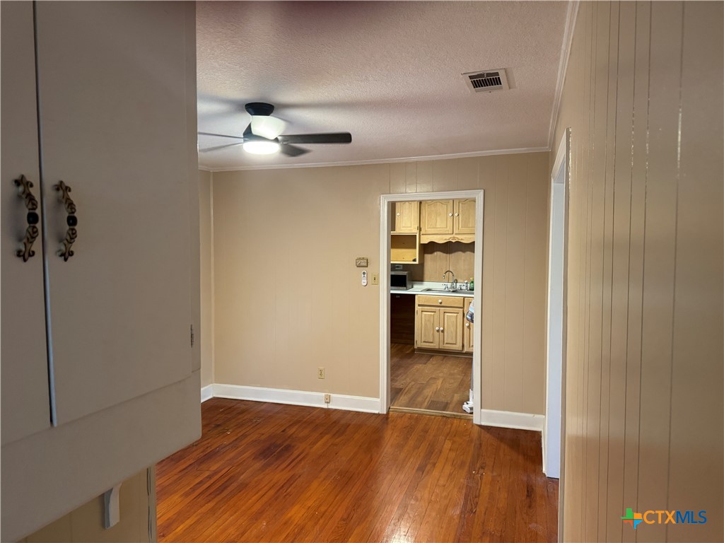 3510 Gun Club Road Temple, TX 76501 - Photo 12 of 17 wooden floor in an empty room and a kitchen