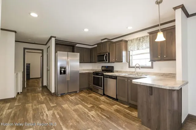 a kitchen with stainless steel appliances granite countertop a sink a stove a refrigerator and a oven