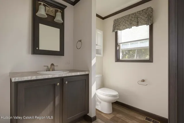 a bathroom with a granite countertop toilet sink and mirror