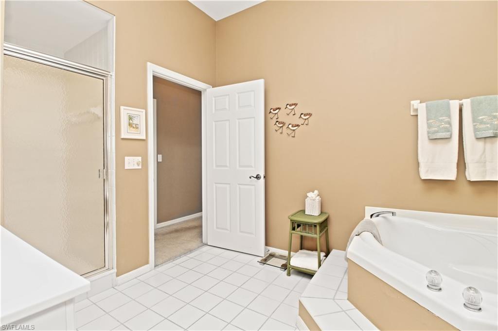 970 Egrets Run, Unit 201 Naples, FL 34108 - Photo 18 of 50 a bathroom with a tub and a shower