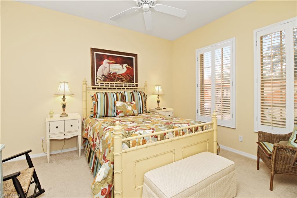 970 Egrets Run, Unit 201 Naples, FL 34108 - Photo 20 of 50 a bedroom with a bed and a chandelier